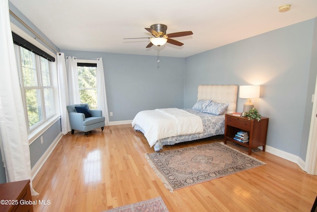 bedroom with baseboards, ceiling fan, and light wood-type flooring