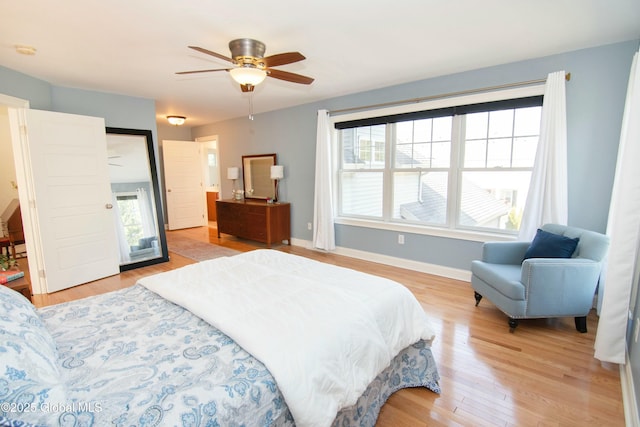 bedroom featuring a ceiling fan, light wood-style flooring, and baseboards