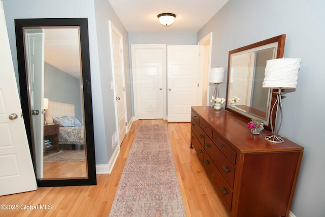 interior space featuring baseboards, light wood-style floors, and visible vents