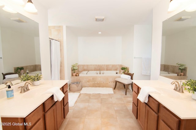 full bath with tile patterned floors, a sink, two vanities, and a bath