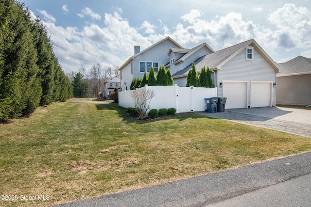 view of front of property featuring fence, driveway, a gate, a front lawn, and a garage