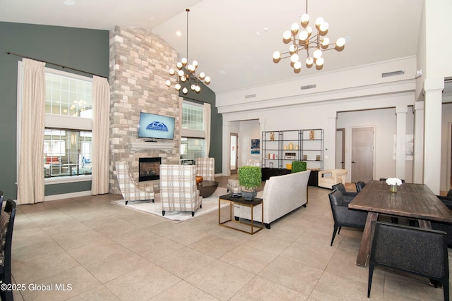 living area featuring light tile patterned flooring, a fireplace, high vaulted ceiling, and a notable chandelier