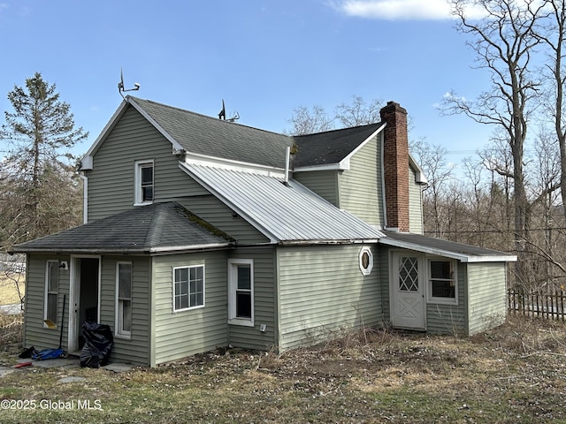 rear view of house featuring a chimney