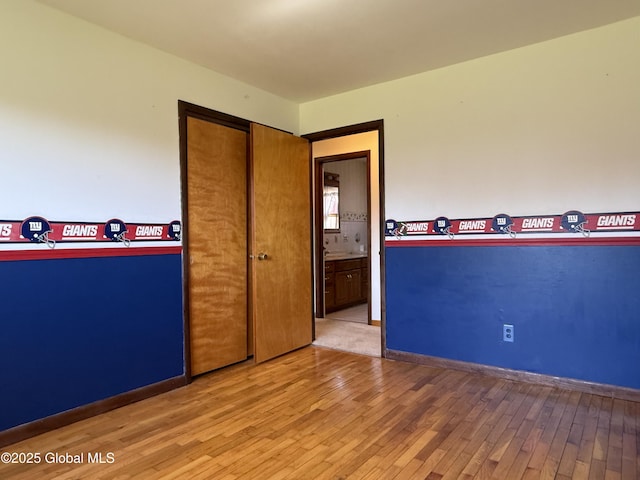 spare room featuring baseboards and hardwood / wood-style floors