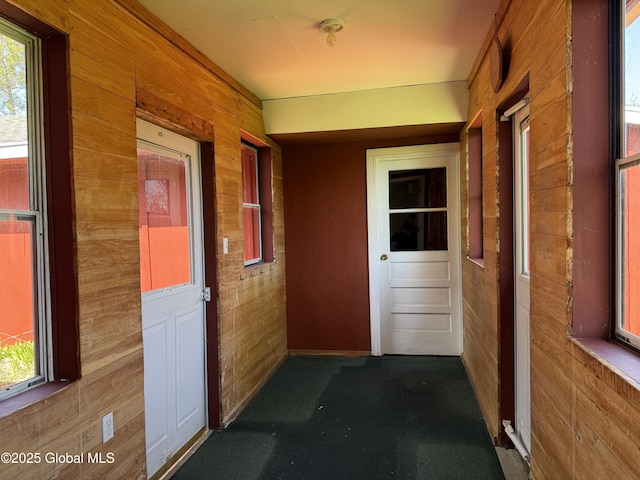corridor with wooden walls and dark carpet