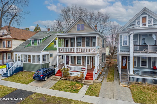 view of front of house featuring a balcony, covered porch, and concrete driveway