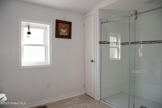 full bathroom with toilet, a stall shower, baseboards, and plenty of natural light