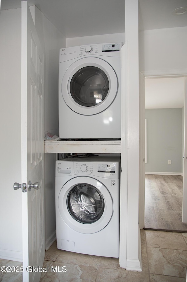 laundry room featuring laundry area, baseboards, and stacked washer and clothes dryer