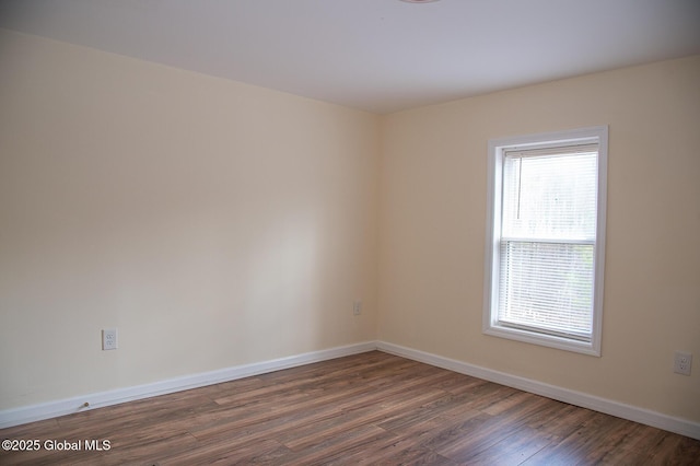 spare room with wood finished floors and baseboards