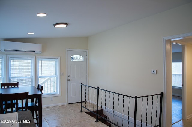 entryway featuring recessed lighting, vaulted ceiling, an AC wall unit, and baseboards