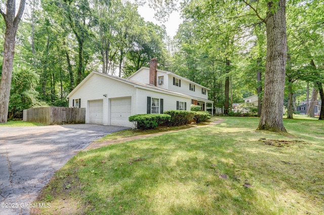 15 Garrison Ln, Clifton Park, NY 12019 - view of front of property with asphalt driveway, a garage, and a chimney