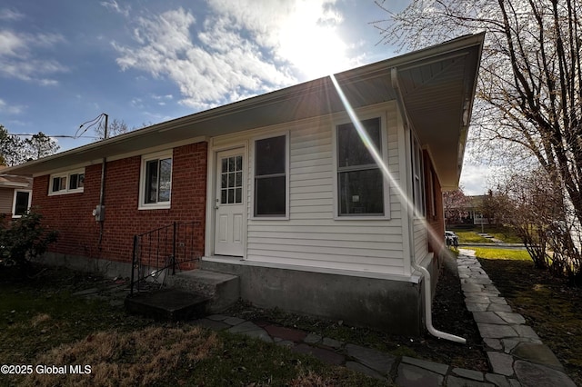 rear view of house featuring entry steps and brick siding