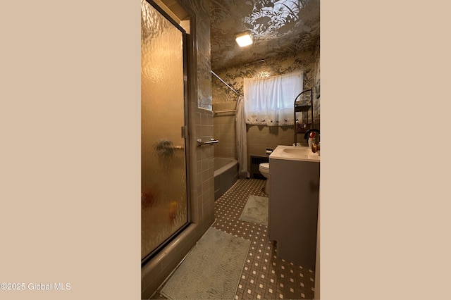 bathroom with vanity, bath / shower combo with glass door, and toilet