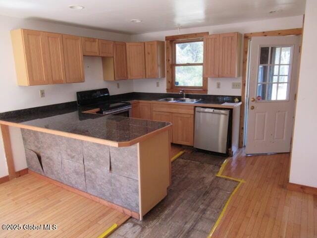 kitchen with dark wood-style flooring, black electric range, dishwasher, a sink, and a peninsula