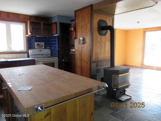 545 Stage Rd, Cambridge, NY 12028 - kitchen featuring light countertops, tasteful backsplash, a wood stove, a center island, and white range with electric stovetop