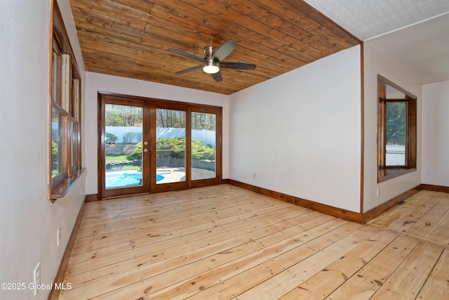 spare room with light wood-type flooring, baseboards, and ceiling fan
