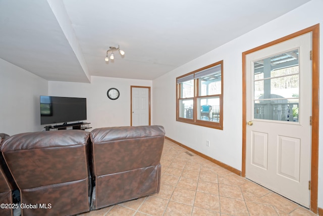 living area featuring light tile patterned floors, baseboards, visible vents, and a healthy amount of sunlight