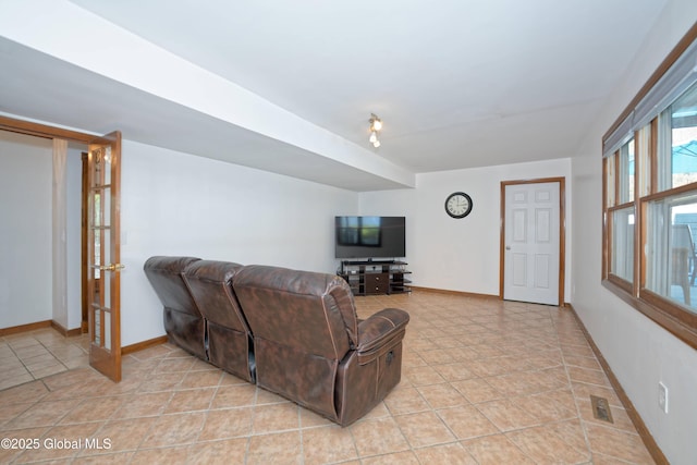 living area with baseboards and light tile patterned floors