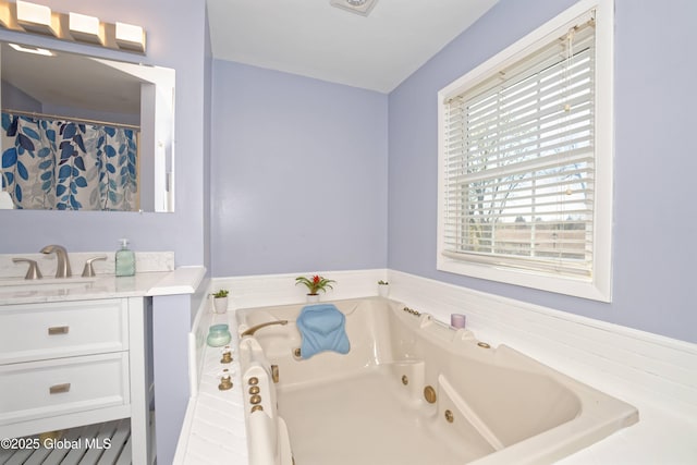 bathroom with a whirlpool tub and vanity