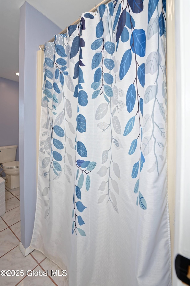 full bath featuring tile patterned flooring and toilet