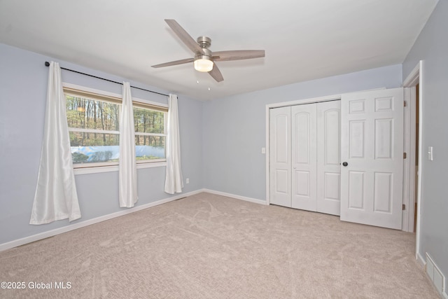 unfurnished bedroom featuring carpet flooring, baseboards, visible vents, and a closet