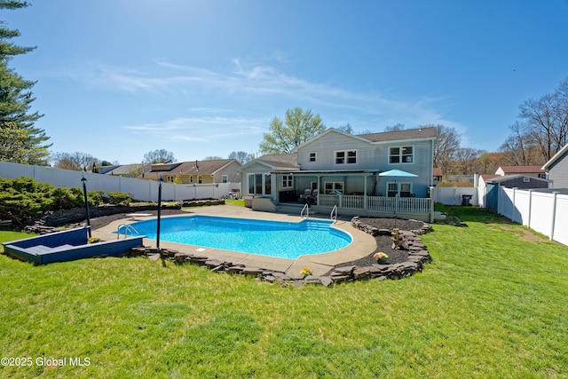 view of swimming pool with a yard, a deck, a fenced in pool, and a fenced backyard