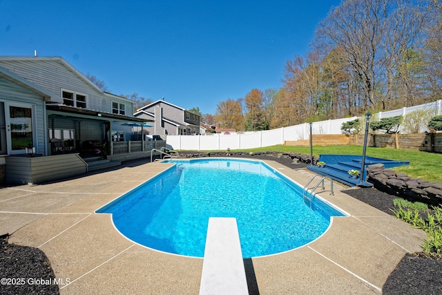 view of swimming pool with a diving board, a fenced in pool, a fenced backyard, and a patio area