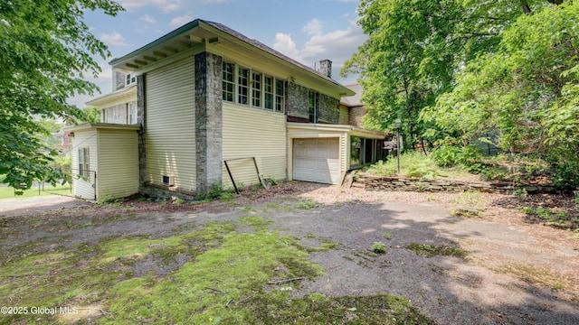 121 Guy Park Ave, Amsterdam, NY 12010 - view of property exterior with a garage, asphalt driveway, and a chimney