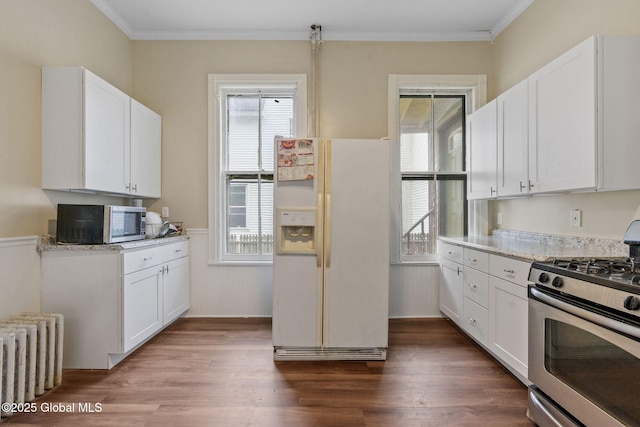 kitchen featuring stainless steel appliances, radiator heating unit, dark wood-type flooring, crown molding, and white cabinets