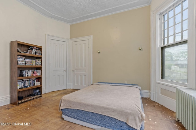 bedroom with radiator, crown molding, and baseboards
