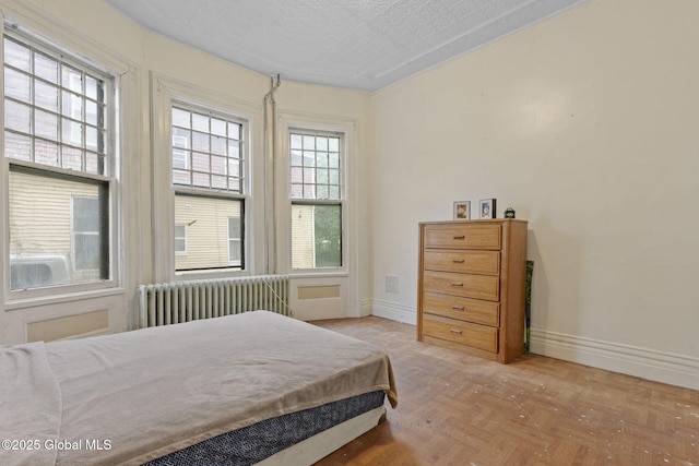 bedroom featuring radiator heating unit and baseboards