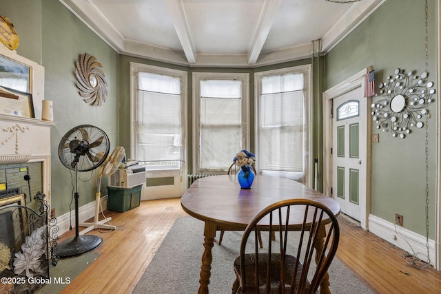 dining room featuring beam ceiling, hardwood / wood-style flooring, healthy amount of natural light, and baseboards