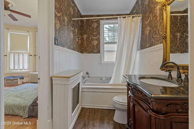 ensuite bathroom featuring radiator heating unit, a wainscoted wall, crown molding, a bath, and wood finished floors