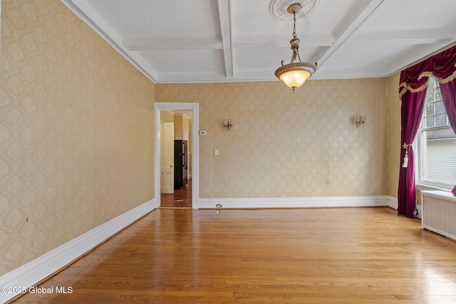 unfurnished room with light wood-type flooring, coffered ceiling, radiator, beam ceiling, and baseboards