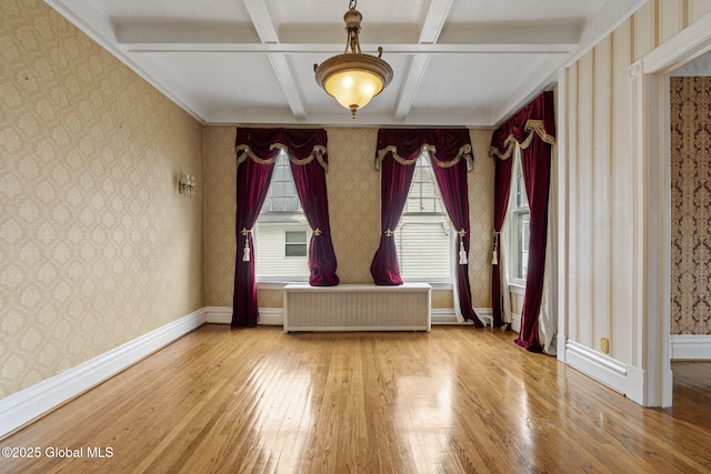 unfurnished room featuring radiator heating unit, hardwood / wood-style flooring, wallpapered walls, coffered ceiling, and beam ceiling