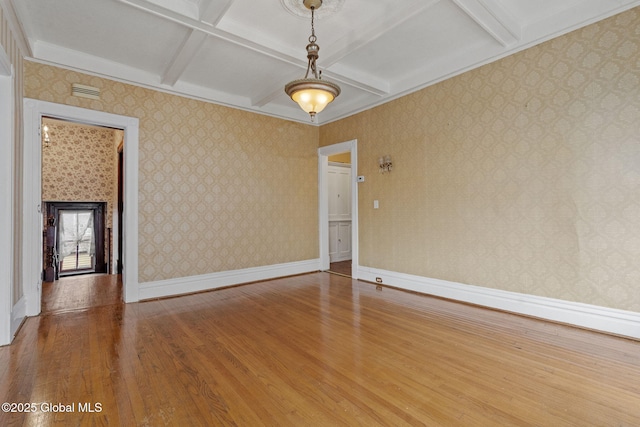spare room with wood finished floors, coffered ceiling, baseboards, and beam ceiling