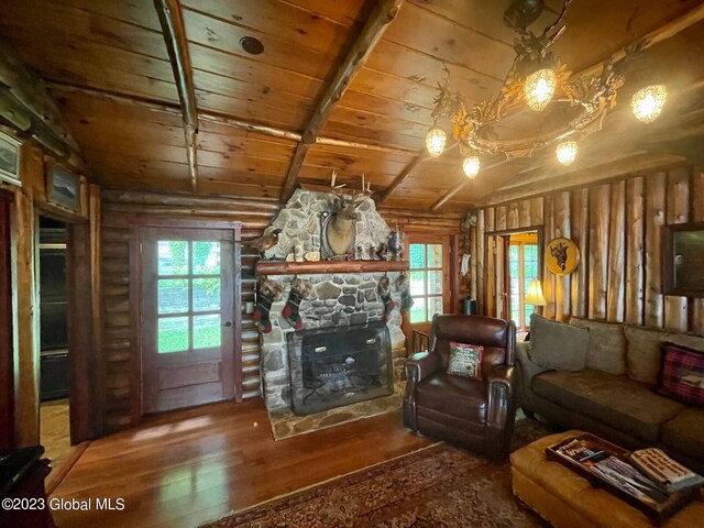 9667 Lake Shore Dr, Hague, NY 12836 - living area featuring wooden ceiling, wood-type flooring, vaulted ceiling, a stone fireplace, and rustic walls
