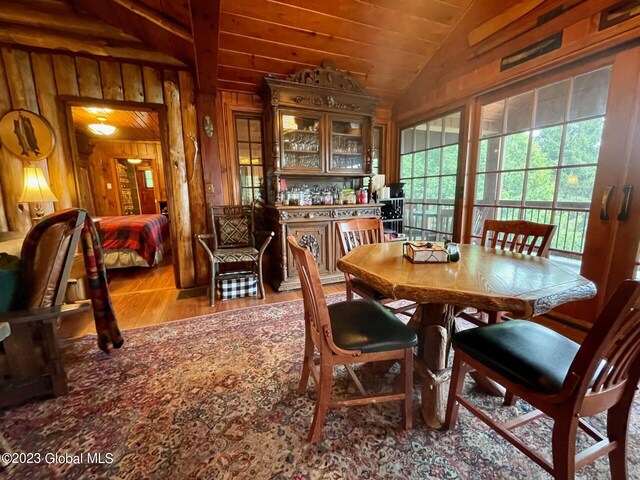 9667 Lake Shore Dr, Hague, NY 12836 - dining room with lofted ceiling, wood finished floors, and wooden walls