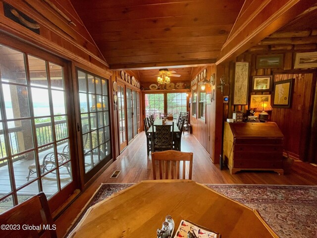 9667 Lake Shore Dr, Hague, NY 12836 - dining space featuring wood finished floors, wood ceiling, wooden walls, a ceiling fan, and lofted ceiling
