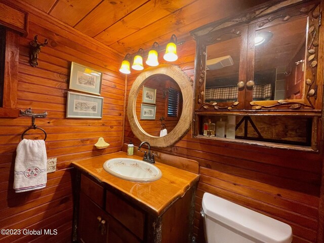 9667 Lake Shore Dr, Hague, NY 12836 - bathroom featuring toilet, vanity, wood walls, and wood ceiling