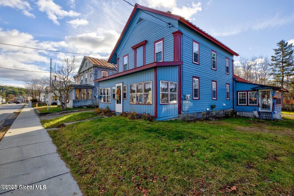17 Hudson St, Warrensburg, NY 12885 - view of home's exterior with a sunroom and a yard