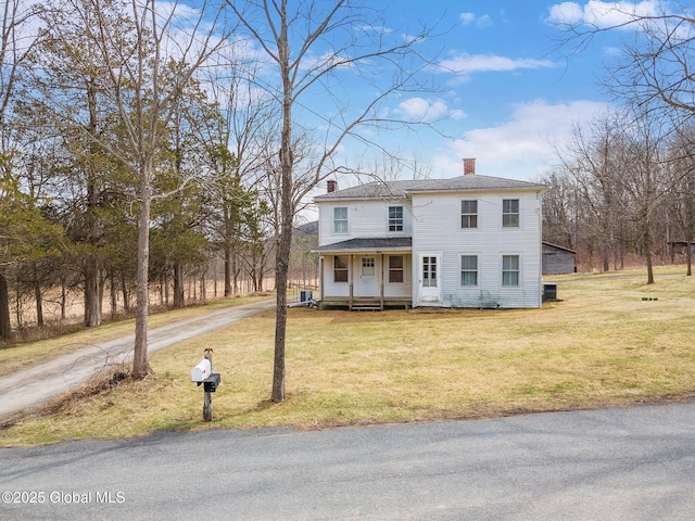 view of front of house with covered porch, dirt driveway, a chimney, a front yard, and a shingled roof