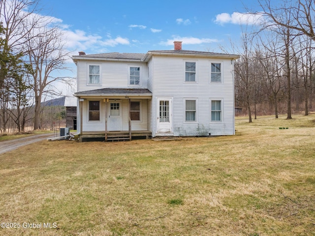 view of front of house with driveway, a chimney, central AC unit, and a front yard
