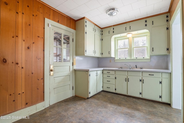 kitchen featuring light countertops, a sink, and crown molding