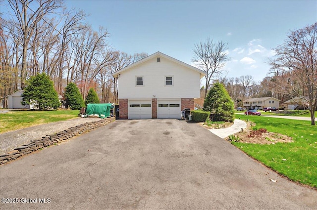 53 Harmon Rd, Glenville, NY 12302 - view of property exterior featuring an attached garage, asphalt driveway, brick siding, and a yard