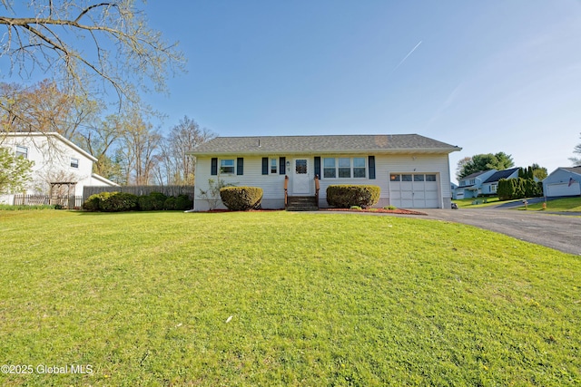 ranch-style home featuring aphalt driveway, fence, a front lawn, an attached garage, and entry steps