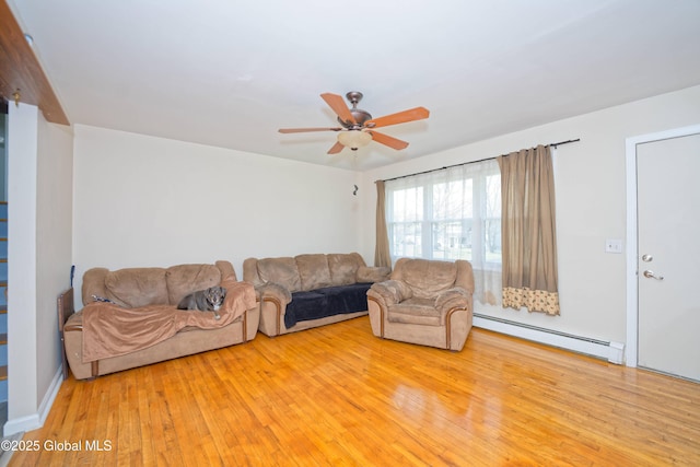 living room with ceiling fan, a baseboard heating unit, and wood finished floors