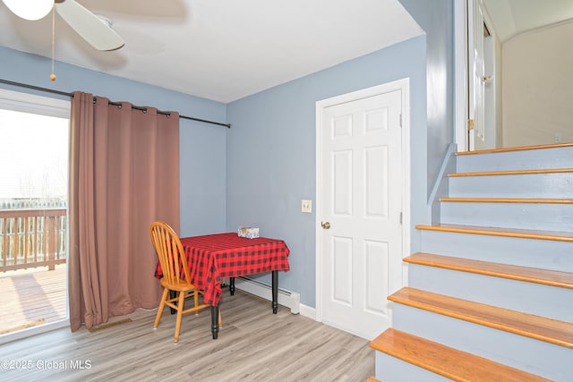 stairway with baseboards, ceiling fan, baseboard heating, and wood finished floors