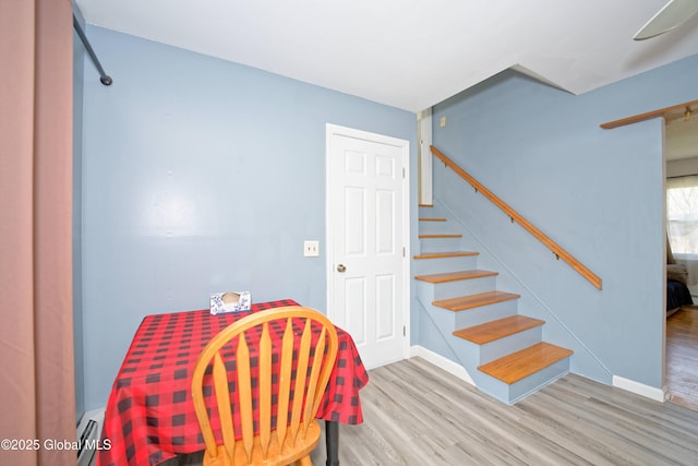 interior space featuring baseboards, wood finished floors, and stairway