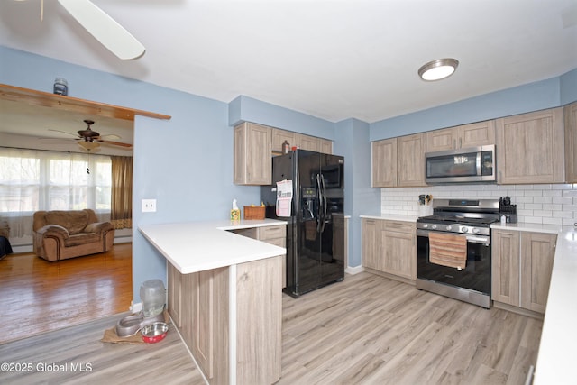 kitchen featuring light wood-style floors, a peninsula, appliances with stainless steel finishes, and light brown cabinetry